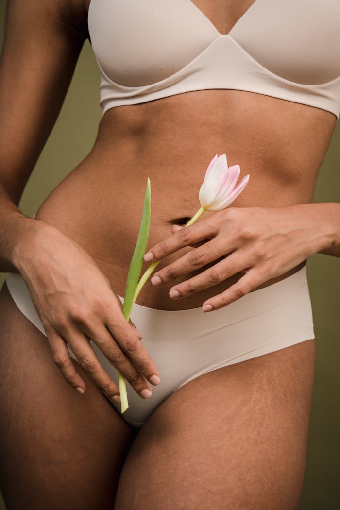 our-services-2 Close-up of a woman's body in lingerie holding a tulip, symbolizing natural beauty and confidence.
